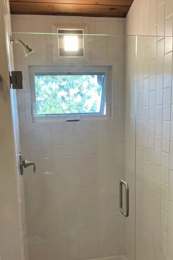 Bathroom remodel featuring walk-in shower with glass enclosure and white tile surround in a southwest hills Portland home